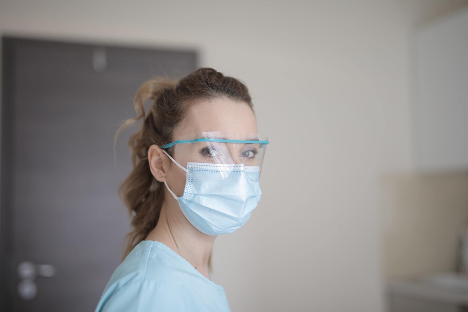 Woman nurse in blue shirt wearing face mask